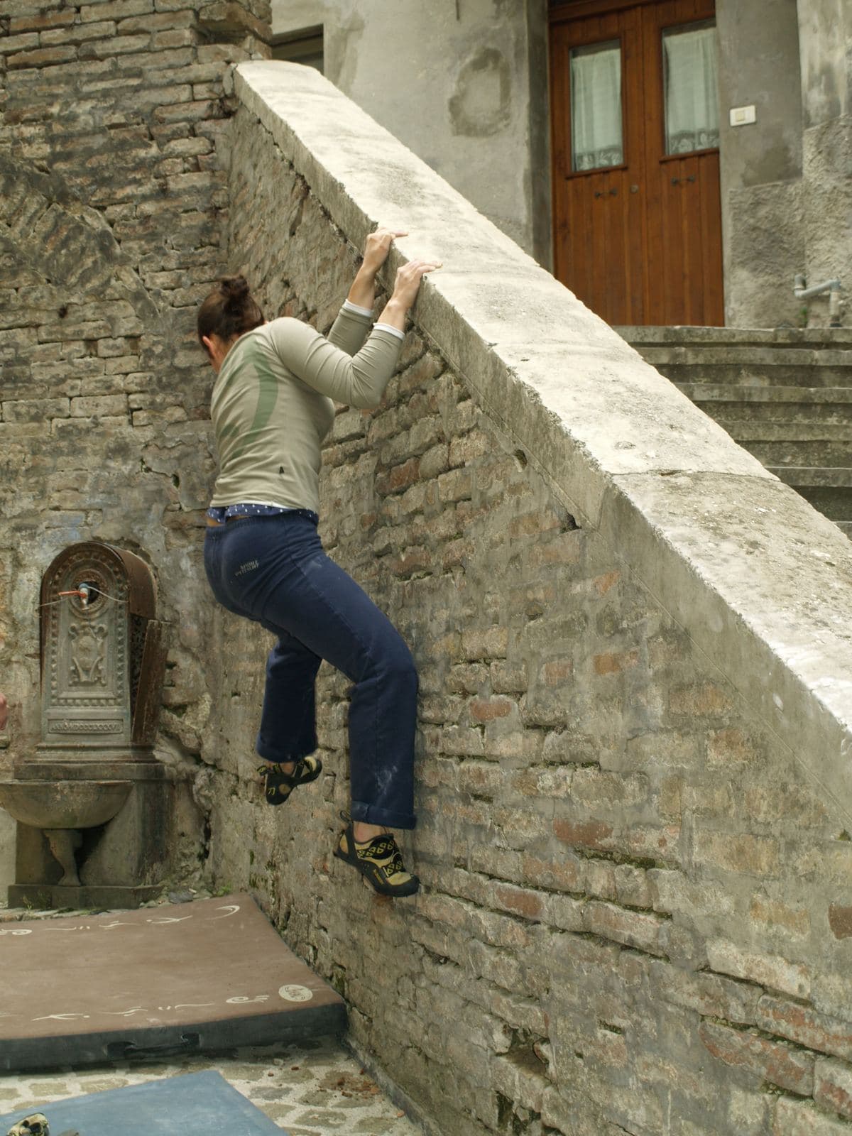 Una ragazza in traverso sul muro di una scalinata